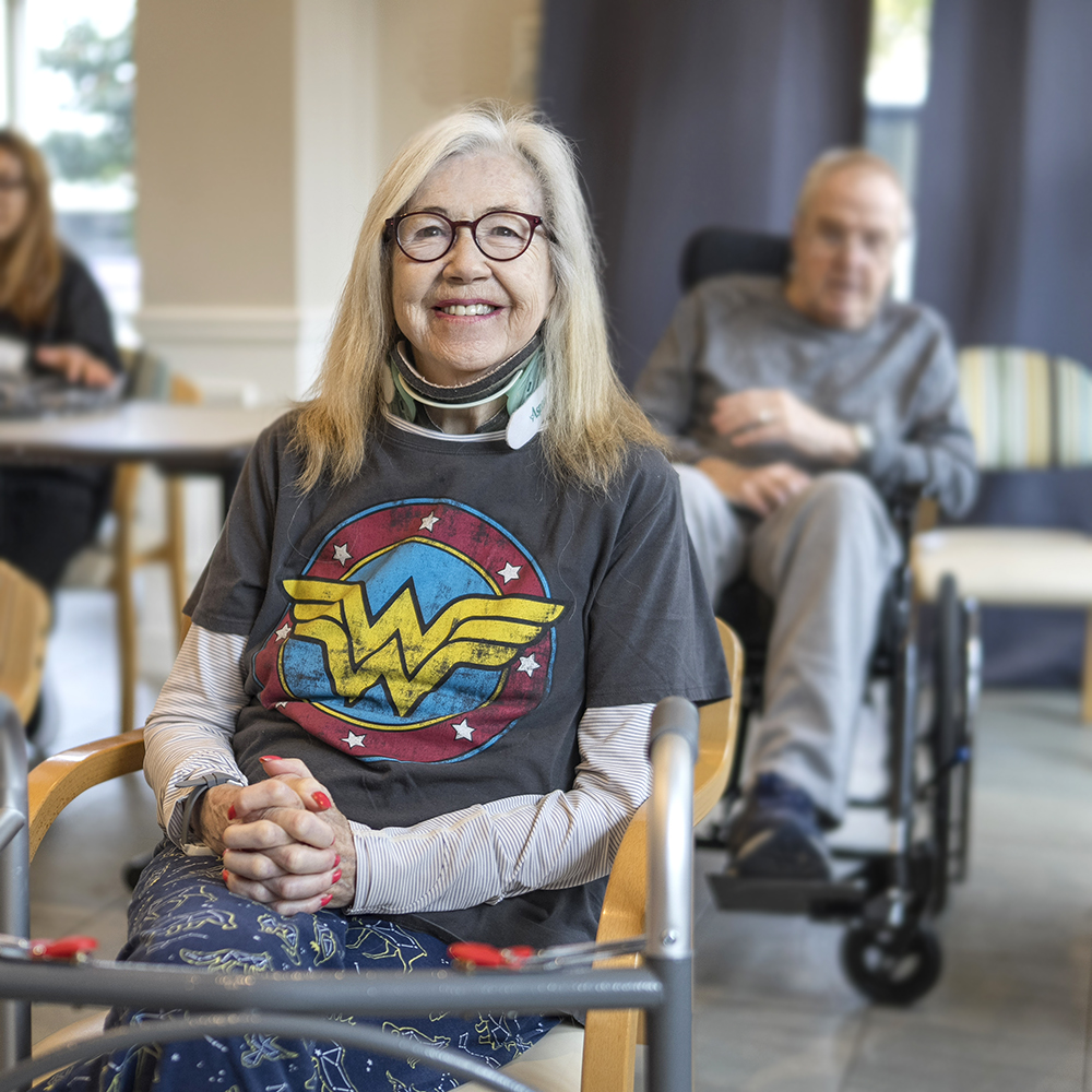 Resident smiling during recovery while enjoying social time in the lounge at Atrium Retirement Residence in Orillia